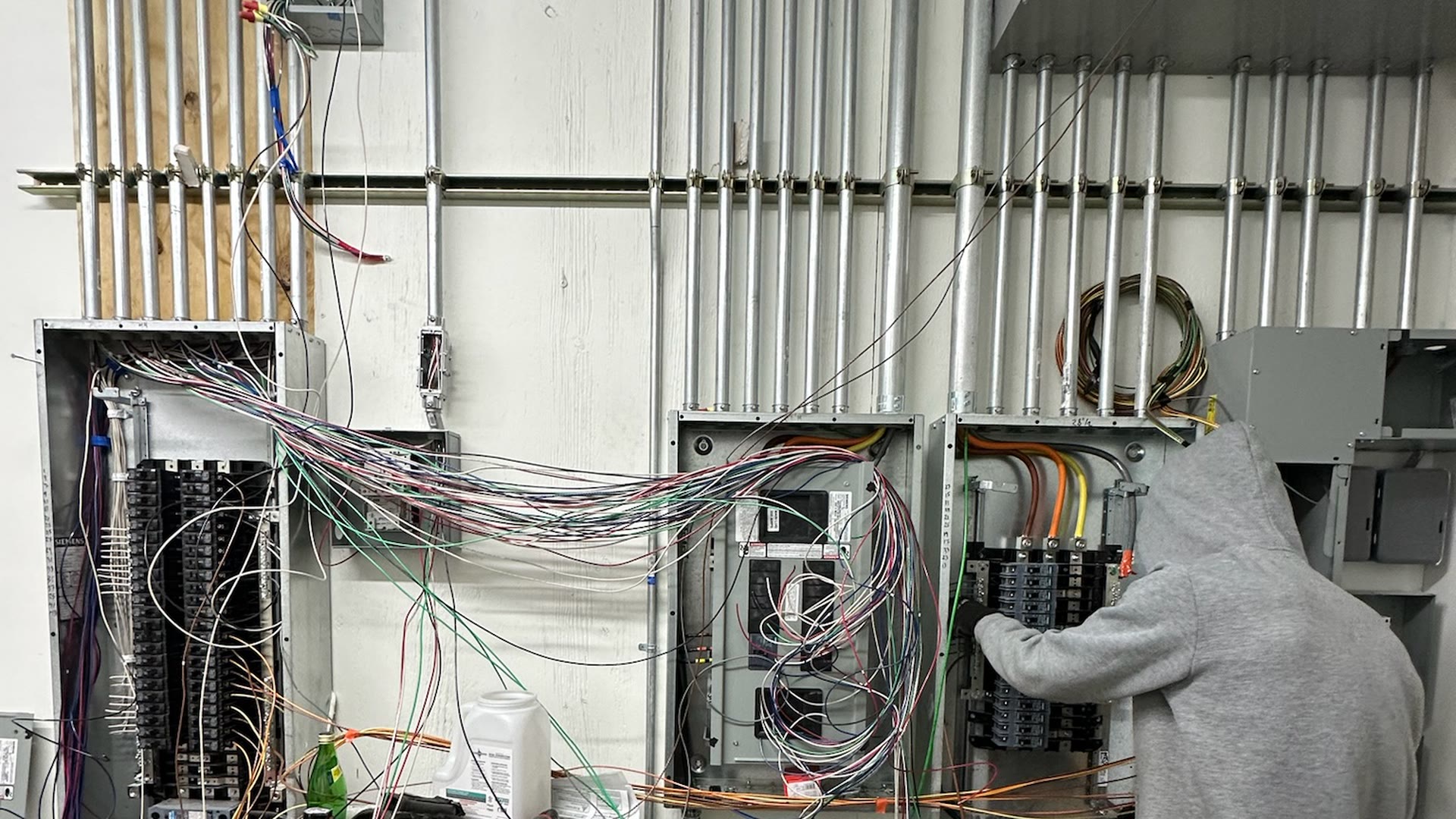 An ARCED crew member working on an electrical panel installation